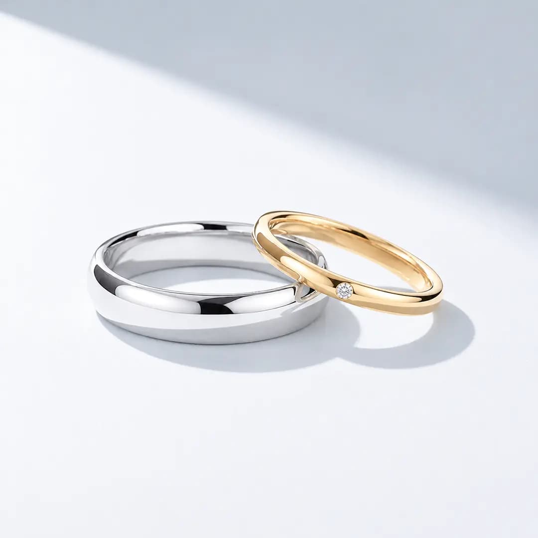A platinum and a yellow gold wedding band resting together